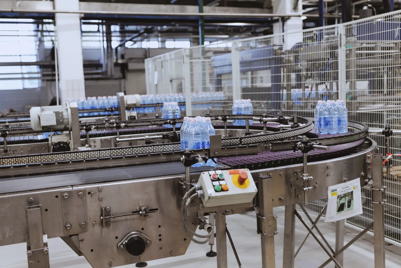 Een bottellijn voor dranken in een koel verlichte EU-fabriek