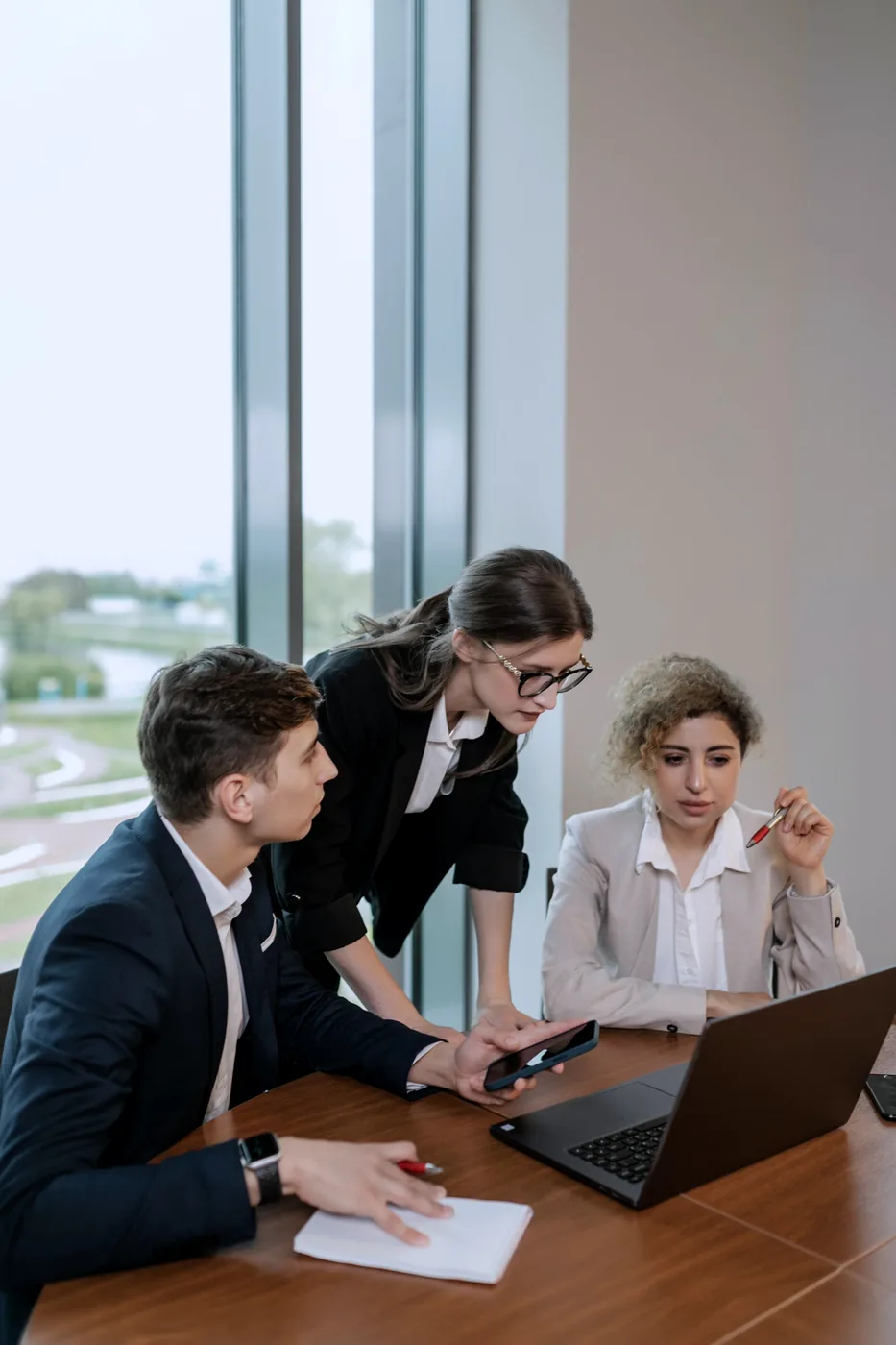 Een team bekijkt sourcingvoorwaarden op een laptop