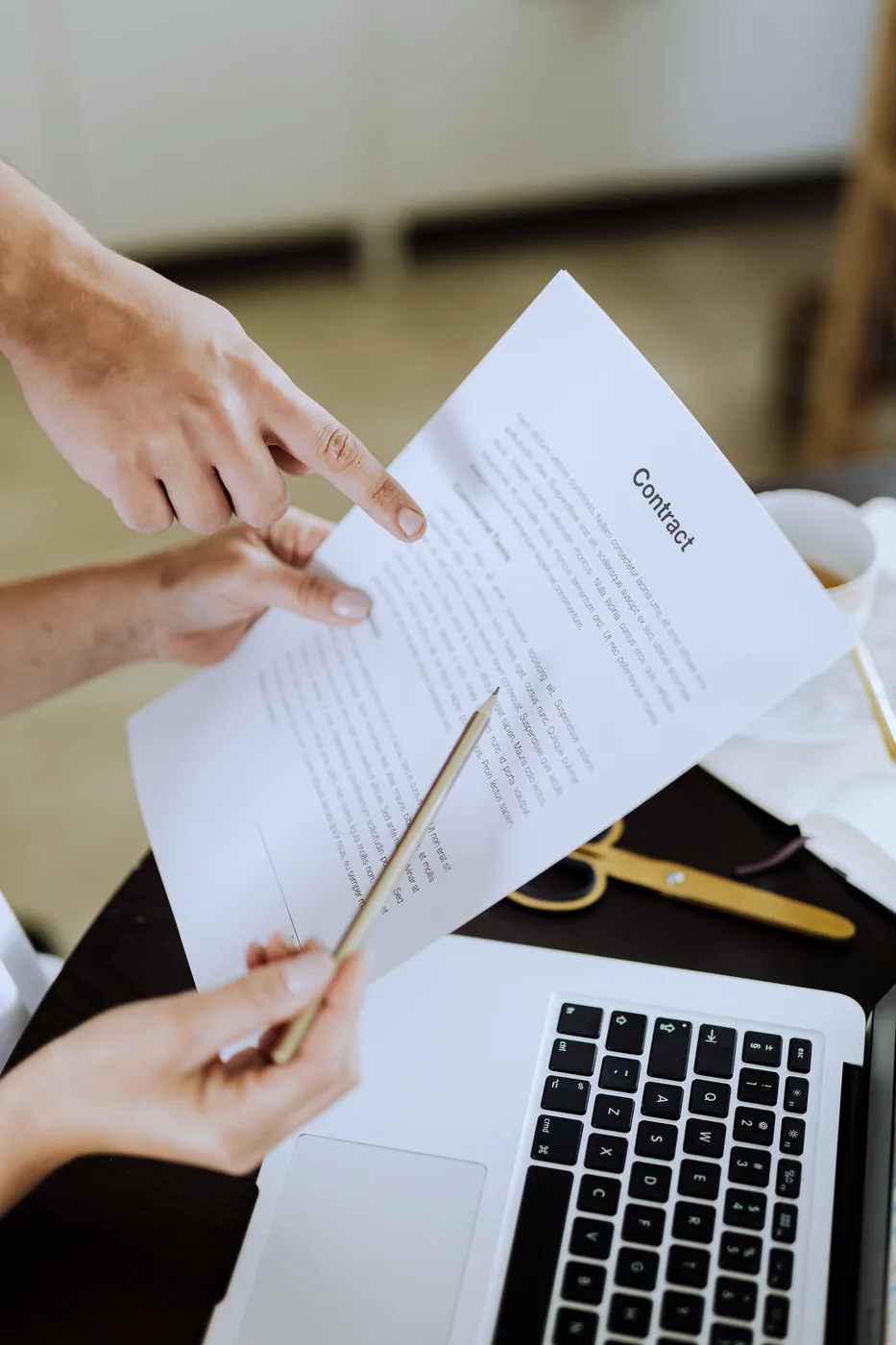 Handen bekijken contractvoorwaarden op een laptop
