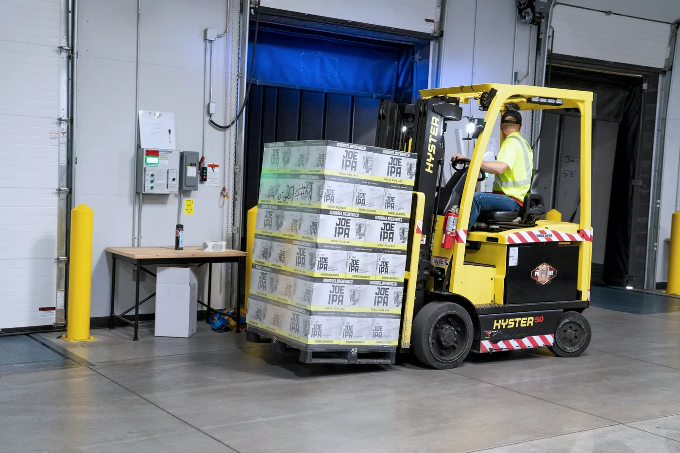 Een heftruck verplaatst pallets door een EU-distributiemagazijn met stellingen